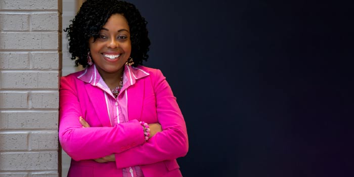 Woman in pink standing in front of building