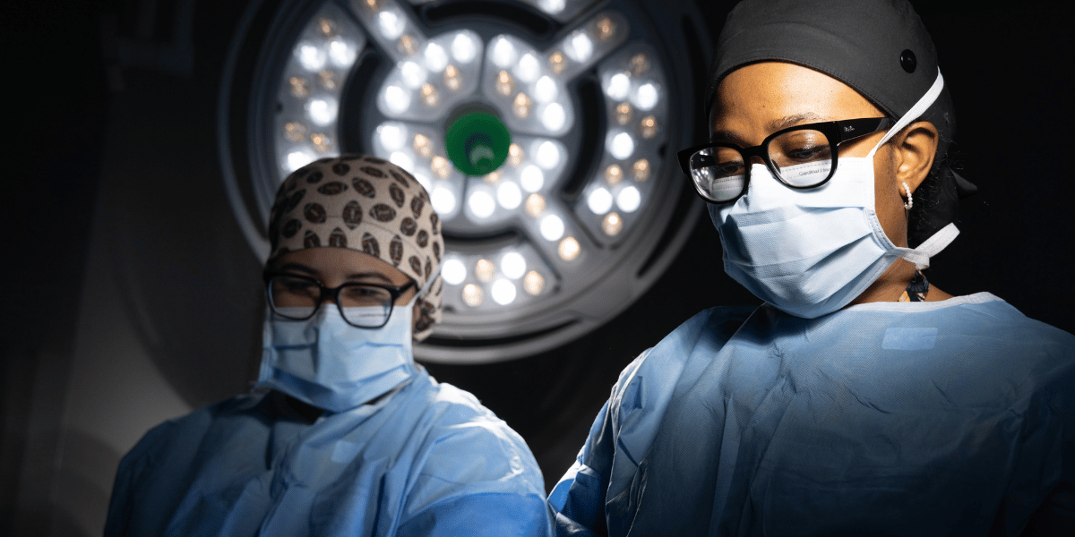 Masked faces of two surgeons at work in OR