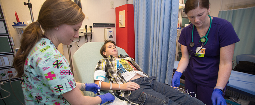 Nurses working with patient in hospital bed