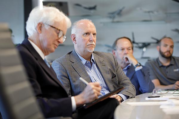 Dr. Michael Chambers (writing), chief economic development officer, and Dr. Michael Capella (next to Chambers), dean of the Mitchell College of Business, visited Wichita State University’s Innovation Campus in April.