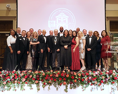 Distinguished Alumni Award recipients standing on stage.