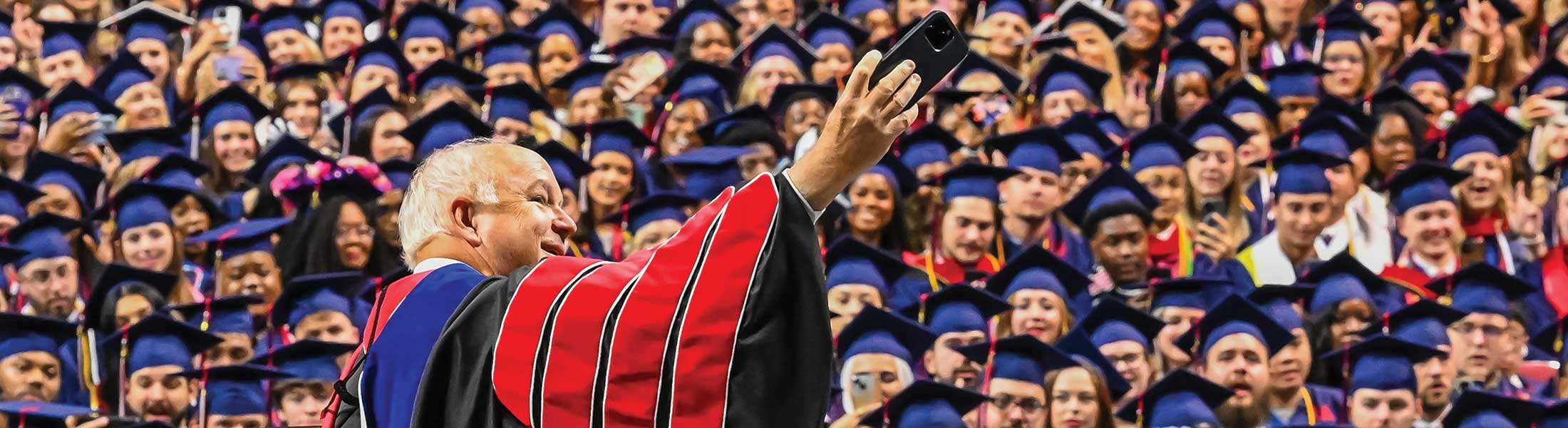 President Bonner taking picture at graduation of graduates.