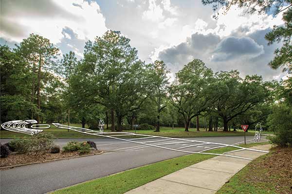 The master plan taking shape calls for improved pedestrian pathways across campus. Two possibilities include a boardwalk over Three Mile Creek, opposite page, and a corridor that would cut across the campus’s central traffic circle, left, pending traffic control measures. An amphitheater could host performances.