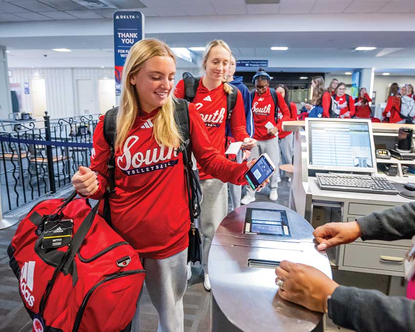 Volleyball team going through line to get on plane.