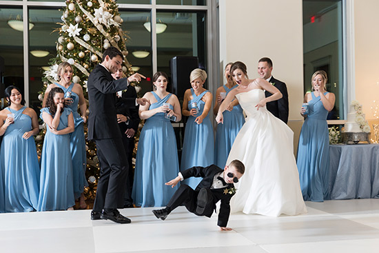 Bride and groom with wedding party watching a child dance at wedding.