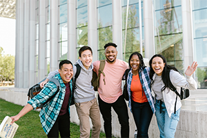 Group of students smiling with arms around each other.