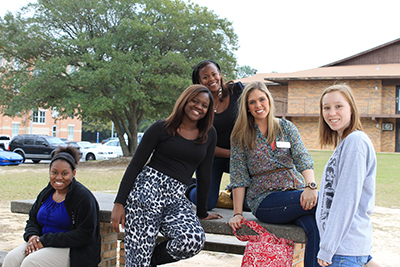 Group of students on bench outside dorms