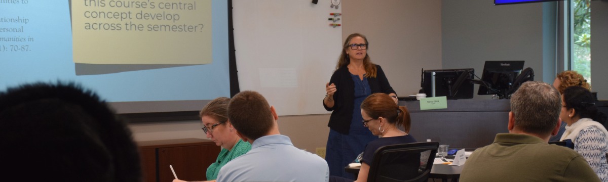 woman talking in front of a room of people sitting at tables